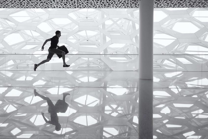 Man running with briefcase through hallway