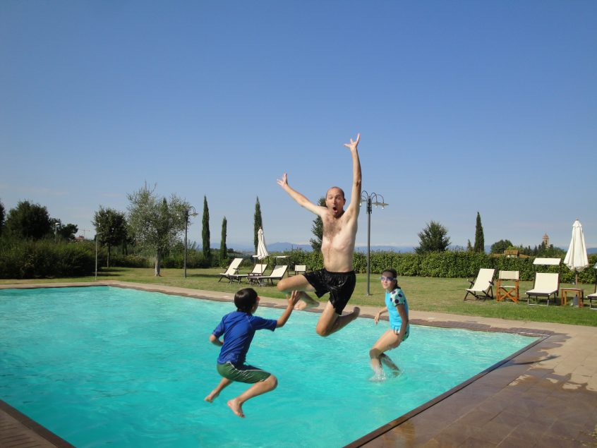 Family jumping into swimming pool